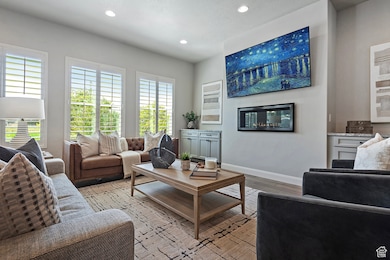 Living area with wood finished floors, recessed lighting, and a glass covered fireplace