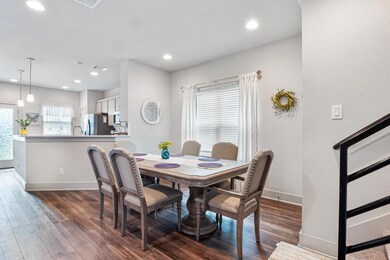 Dining room with dark wood-type flooring and recessed lighting