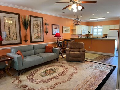 Living area featuring wood finished floors, a ceiling fan, ornamental molding, and recessed lighting