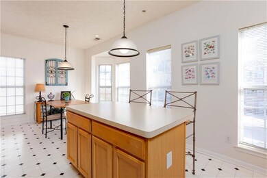 Kitchen featuring a breakfast bar, hanging light fixtures, healthy amount of natural light, and light countertops