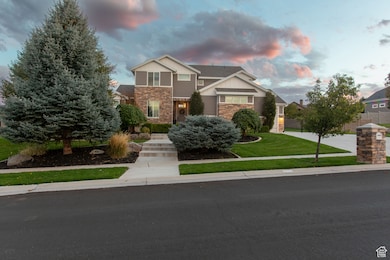 Craftsman-style house featuring stone siding, a front lawn, driveway, a garage, and board and batten siding