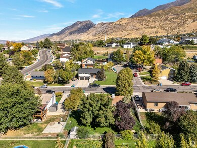 Aerial view of property and surrounding area with a mountainous background and nearby suburban area