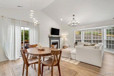 Dining space featuring a fireplace, light wood-style floors, a chandelier, recessed lighting, and high vaulted ceiling