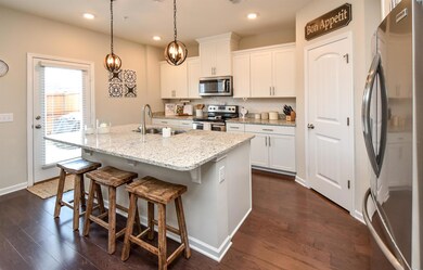 Beautiful cabinetry, upgrade lighting above island, granite, tile backsplash, stainless steel appiances