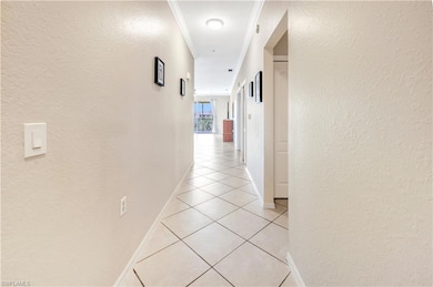 Foyer entrance with crown molding and light tile p