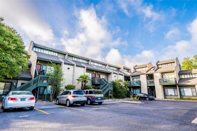 View of building exterior featuring stairs and uncovered parking