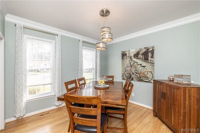 Dining area with crown molding and light bamboo fl