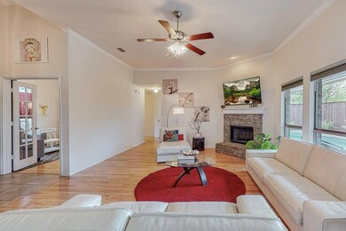 Living room featuring a brick fireplace, ceiling f