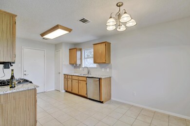 Kitchen with light stone countertops, dishwasher, pendant lighting, a textured ceiling, and a chandelier