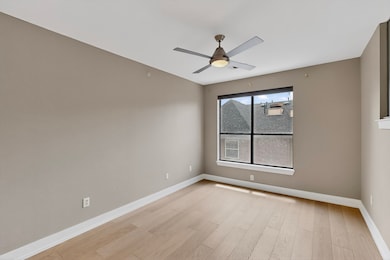 Empty room featuring ceiling fan and light wood-style floors
