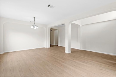 Unfurnished living room featuring a chandelier, a