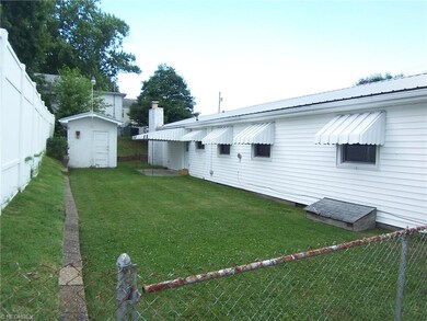 Small fenced back yard with patio and storage bldg