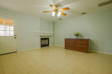 Tiled living area with a fireplace, a ceiling fan