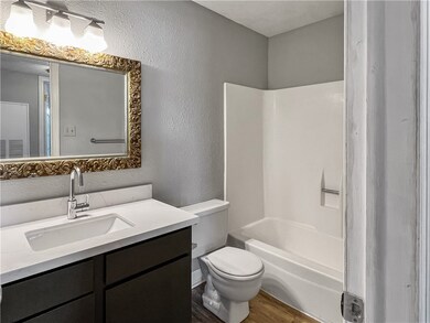 Full bathroom featuring vanity, toilet, wood-type