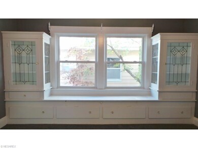 Charming Window Seat flanked by Leaded Glass Cabinets and Storage Underneath