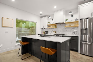 Kitchen featuring light countertops, concrete flo
