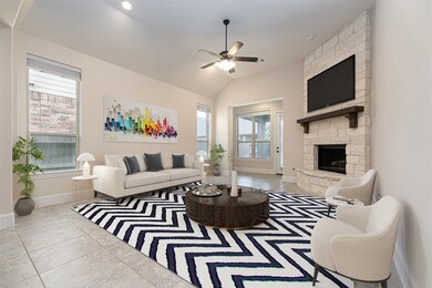 This home features a spacious living room with a stunning stone fireplace, high ceilings, sleek recessed lighting, tile floors, a ceiling fan, and plenty of natural light through the windows!