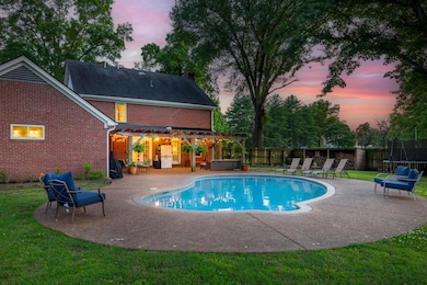 View of pool with a pergola, a patio area, and a trampoline