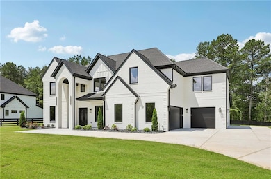 View of front of property featuring driveway, an attached garage, and board and batten siding