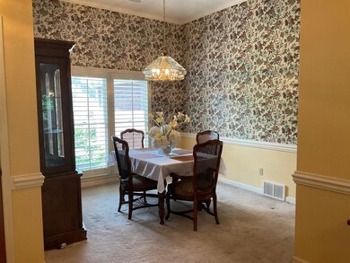 Carpeted dining room with ornamental molding and a