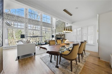 Dining room featuring plenty of natural light, a fireplace, wood finished floors, and crown molding
