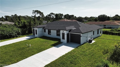 Single story home with roof with shingles, stucco siding, a front yard, and concrete driveway