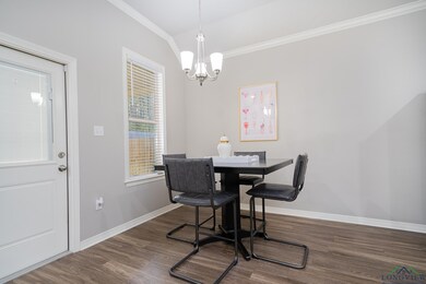 Dining room featuring crown molding, a chandelier, wood finished floors, and lofted ceiling