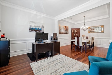 Home office featuring a raised ceiling, crown mold