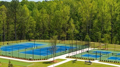 View of tennis court featuring a view of trees