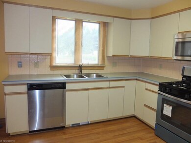 Fully applianced kitchen with tile backsplash.