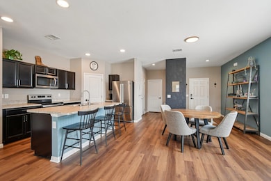 Dining room with recessed lighting and light wood