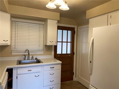 KITCHEN WITH DOOR TO THE BASEMENT AND A DOOR TO THE REAR PATIO.