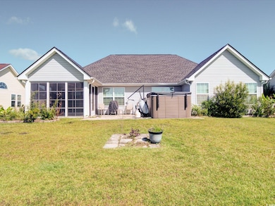 Back of property featuring a sunroom, a yard, a patio area, and roof with shingles