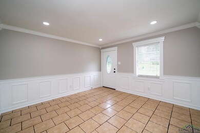 Foyer with ornamental molding, recessed lighting, and a wainscoted wall