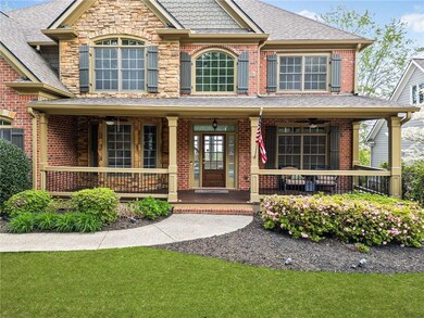 View of front of home featuring roof with shingles, covered porch, ceiling fan, and brick siding