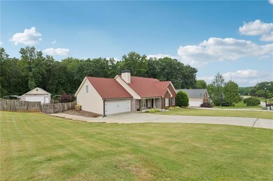 View of front of home featuring driveway, a chimney, and a garage