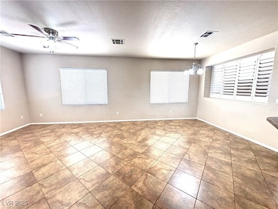 Unfurnished room with a chandelier, a textured cei