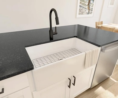Kitchen with white apron-front sink and matte black fixtures
