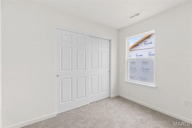 Unfurnished bedroom with light carpet and a closet