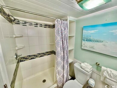 Bathroom with a shower stall and toilet