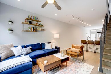 Living room with stairway, ceiling fan, light woo