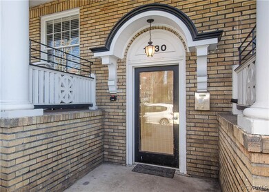 The front entrance has secured entry and decorative architectural details.