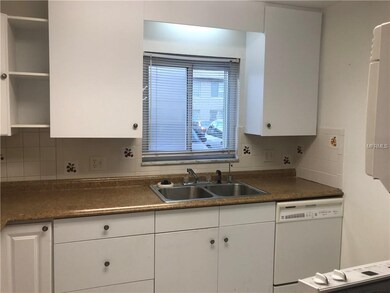 Kitchen has white cabinets and white appliances