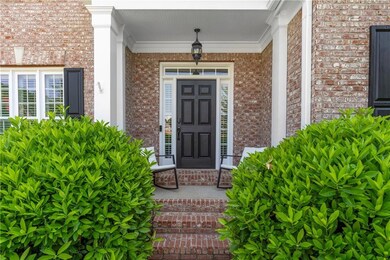 Doorway to property with covered porch and brick siding