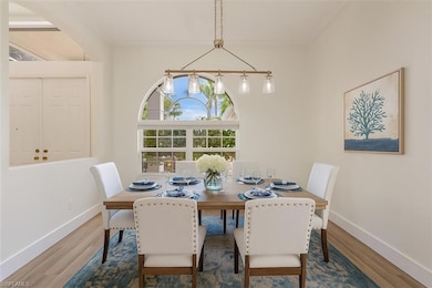 Virtually staged Dining room with new LVP floors and arch window and new designer light fixture