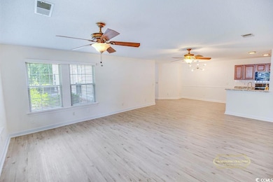 Unfurnished living room featuring light wood finished floors and a ceiling fan