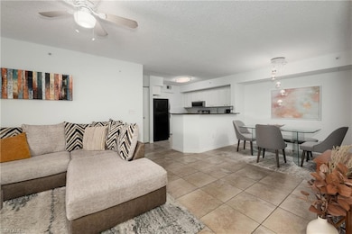 Living room with a textured ceiling, light tile pa