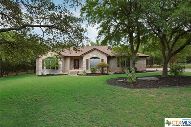 Gorgeous stone exterior with wood shutters shaded by an abundance of mature trees.