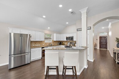 The kitchen is a chef's dream featuring granite countertops, wealth of cabinetry, tons of counter space, and opens to the living room.