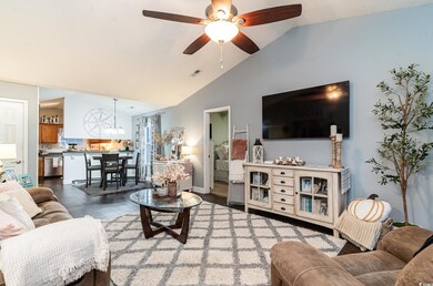 Living room featuring ceiling fan with notable cha